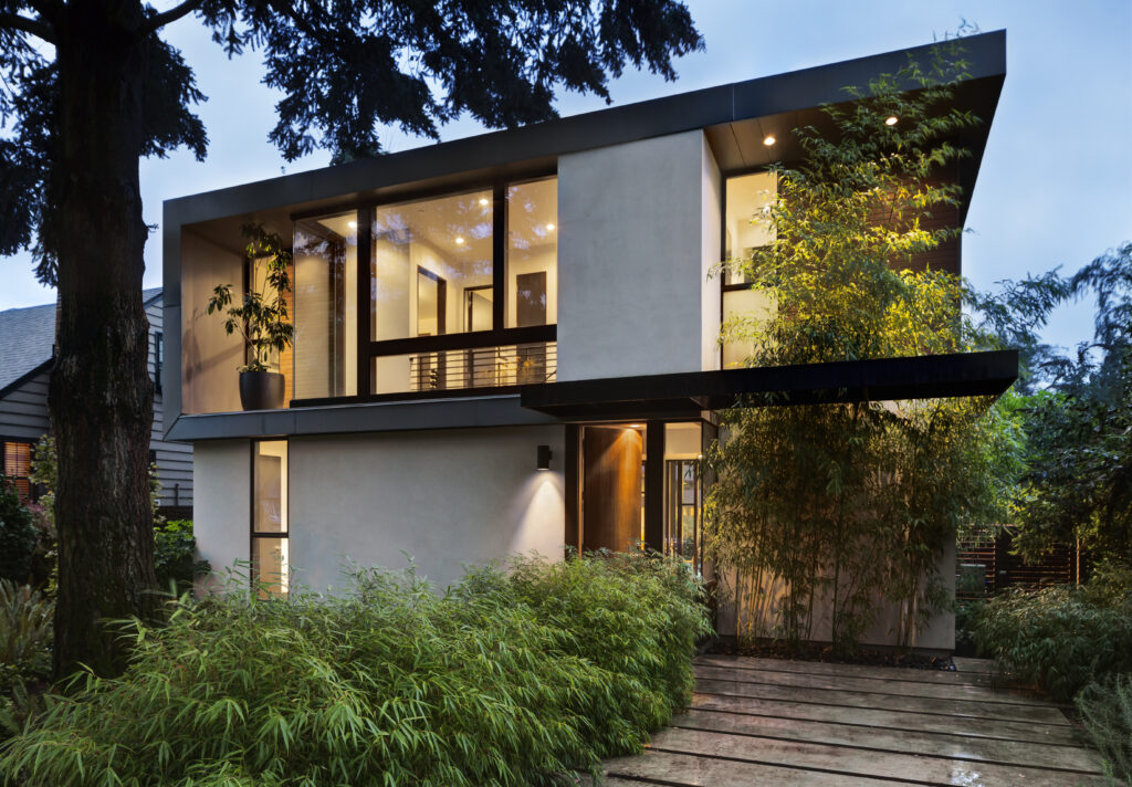 Régisseur, agent immobilier modern home exterior lit at twilight